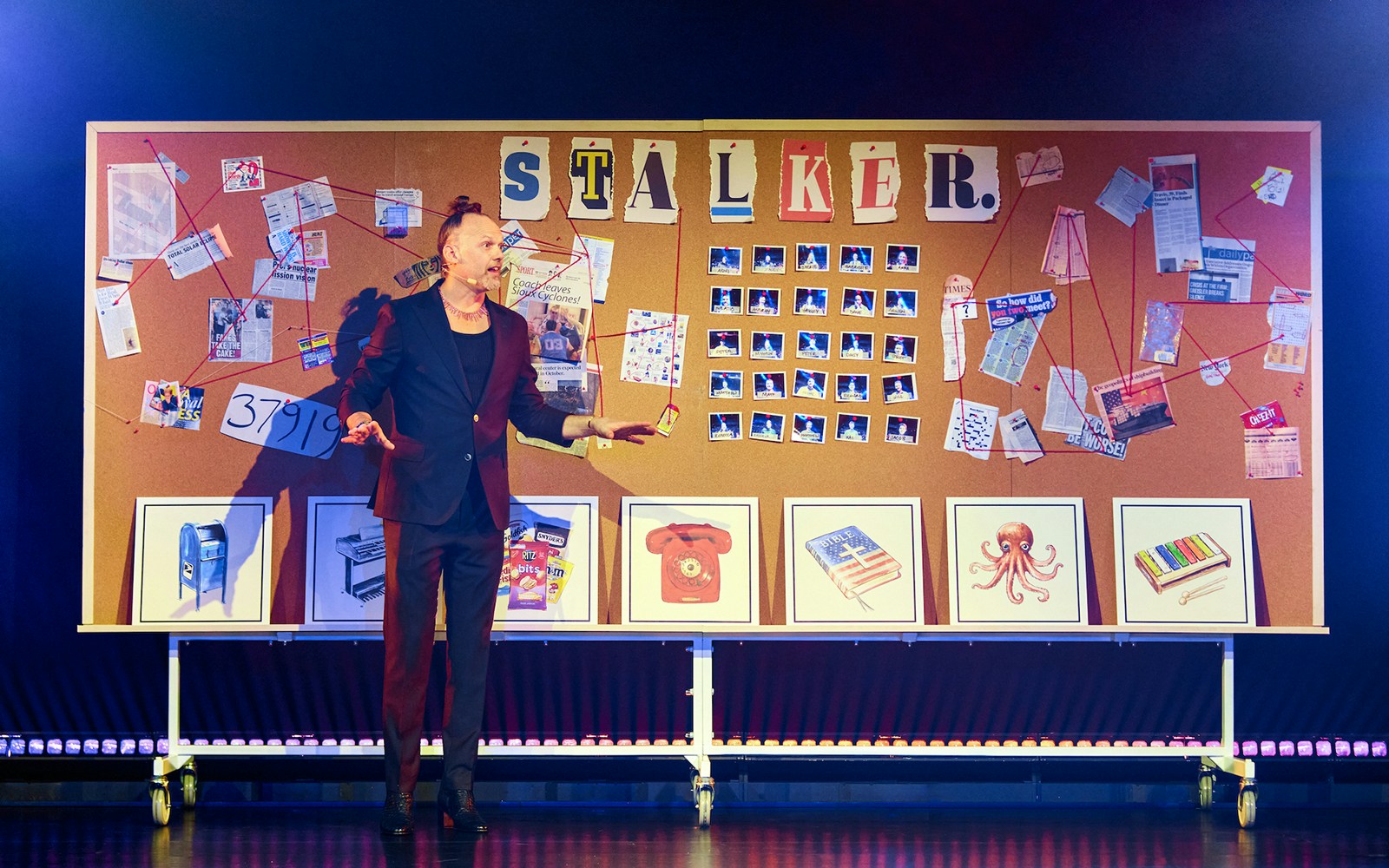 Man presenting in front of a bulletin board with "Stalker" and various photos and notes.