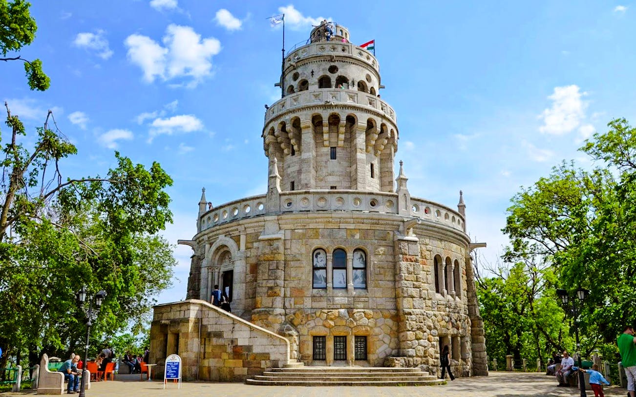 Exterior view of Janos Hill Lookout Tower in Budapest, Hungary, surrounded by trees.