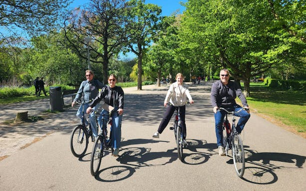 Group biking through a scenic city park on a sunny day.