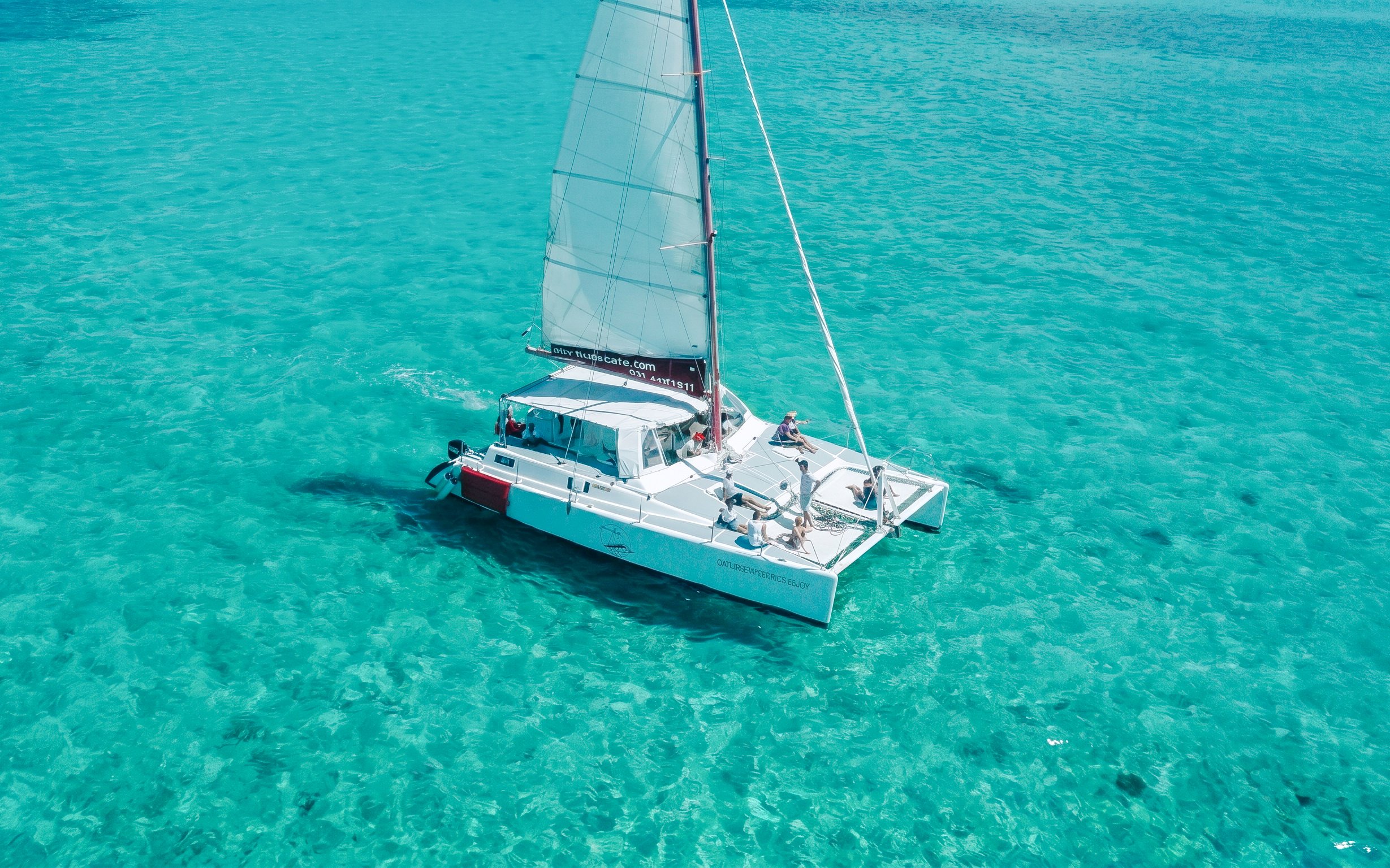 Catamaran sailing on turquoise waters near Ile aux Cerf, Mauritius.