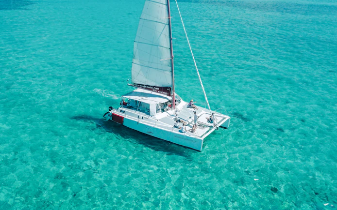 Catamaran sailing on turquoise waters near Ile aux Cerf, Mauritius.