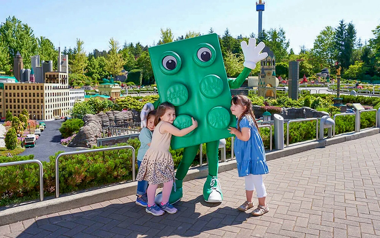 Children hugging a LEGO character at LEGOLAND Deutschland.