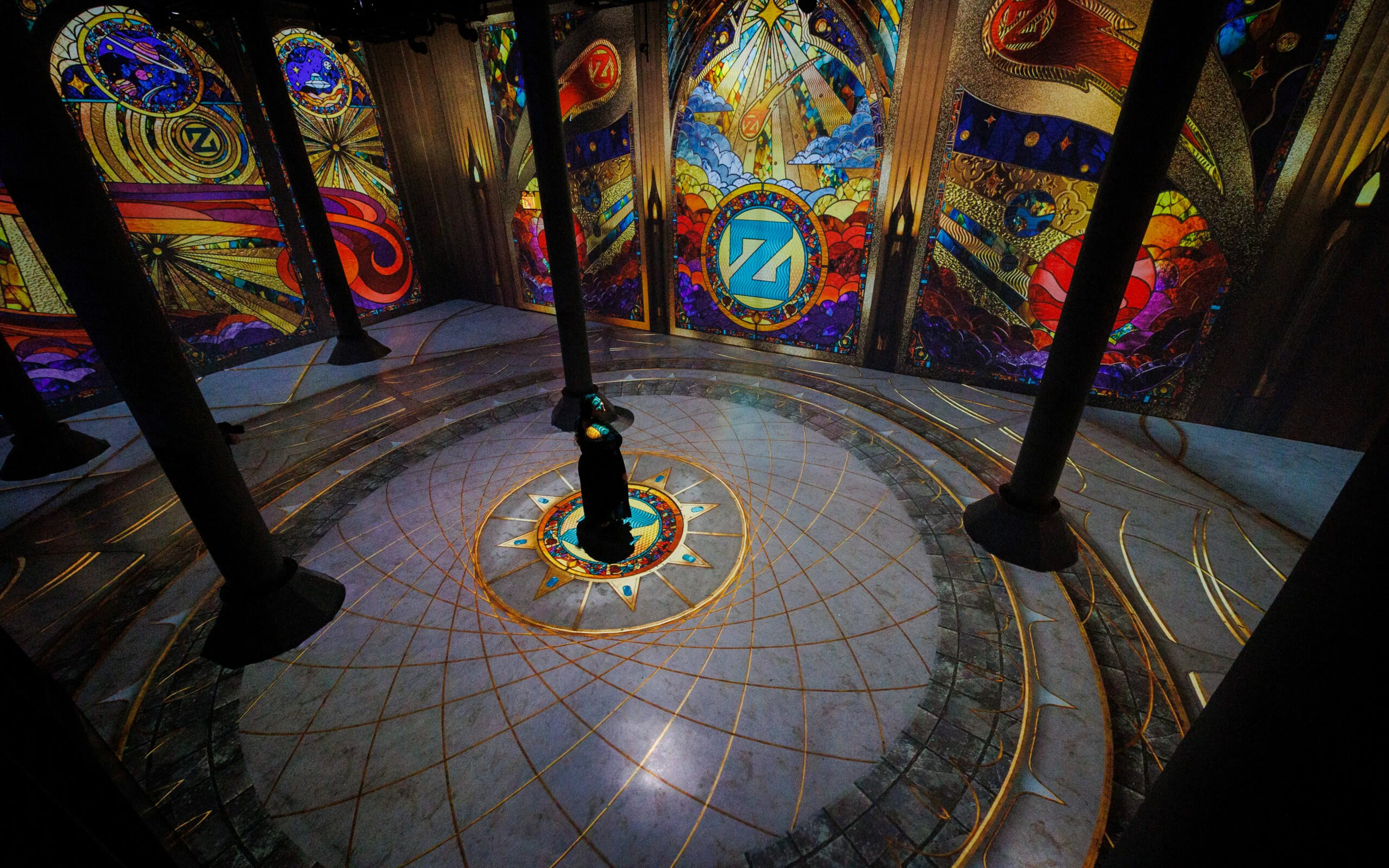 Immersive digital art installation at ARTECHOUSE New York with vibrant stained glass projections.