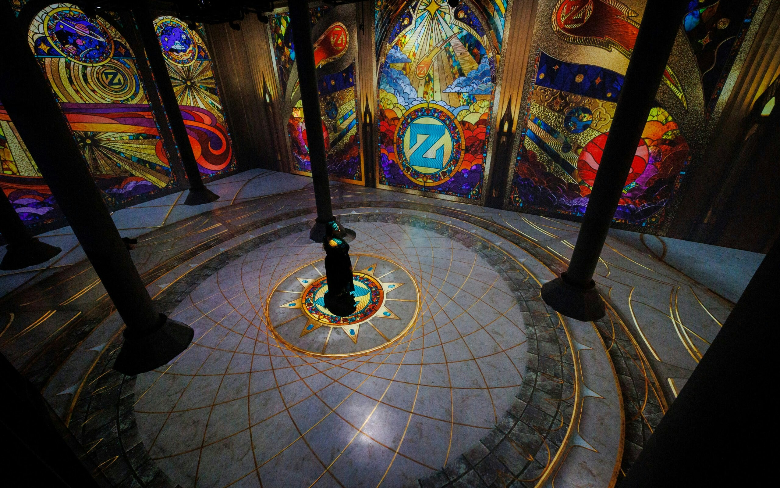 Immersive digital art installation at ARTECHOUSE New York with vibrant stained glass projections.