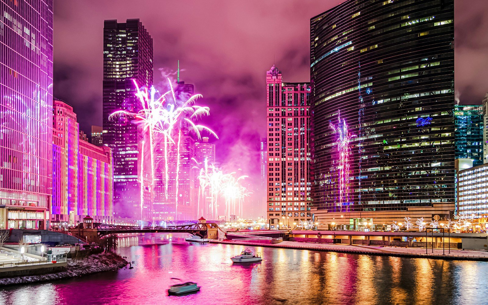 Fireworks display over Wolf Point in Chicago, USA, with city skyline and river.