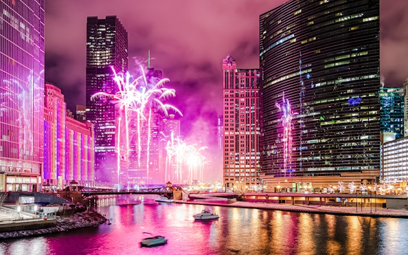 Fireworks display over Wolf Point in Chicago, USA, with city skyline and river.