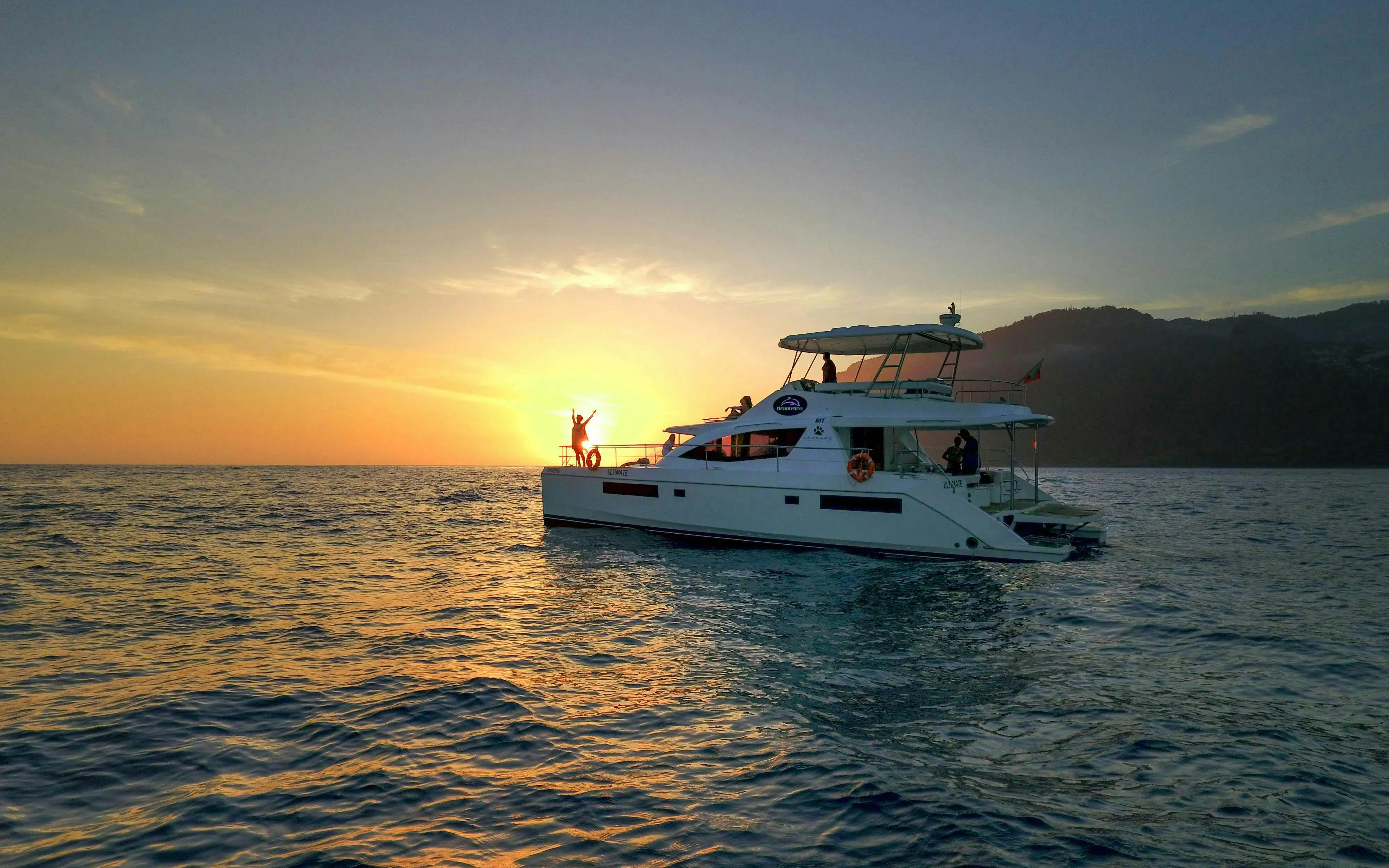 Sunset cruise with people on a boat for dolphin and whale watching.