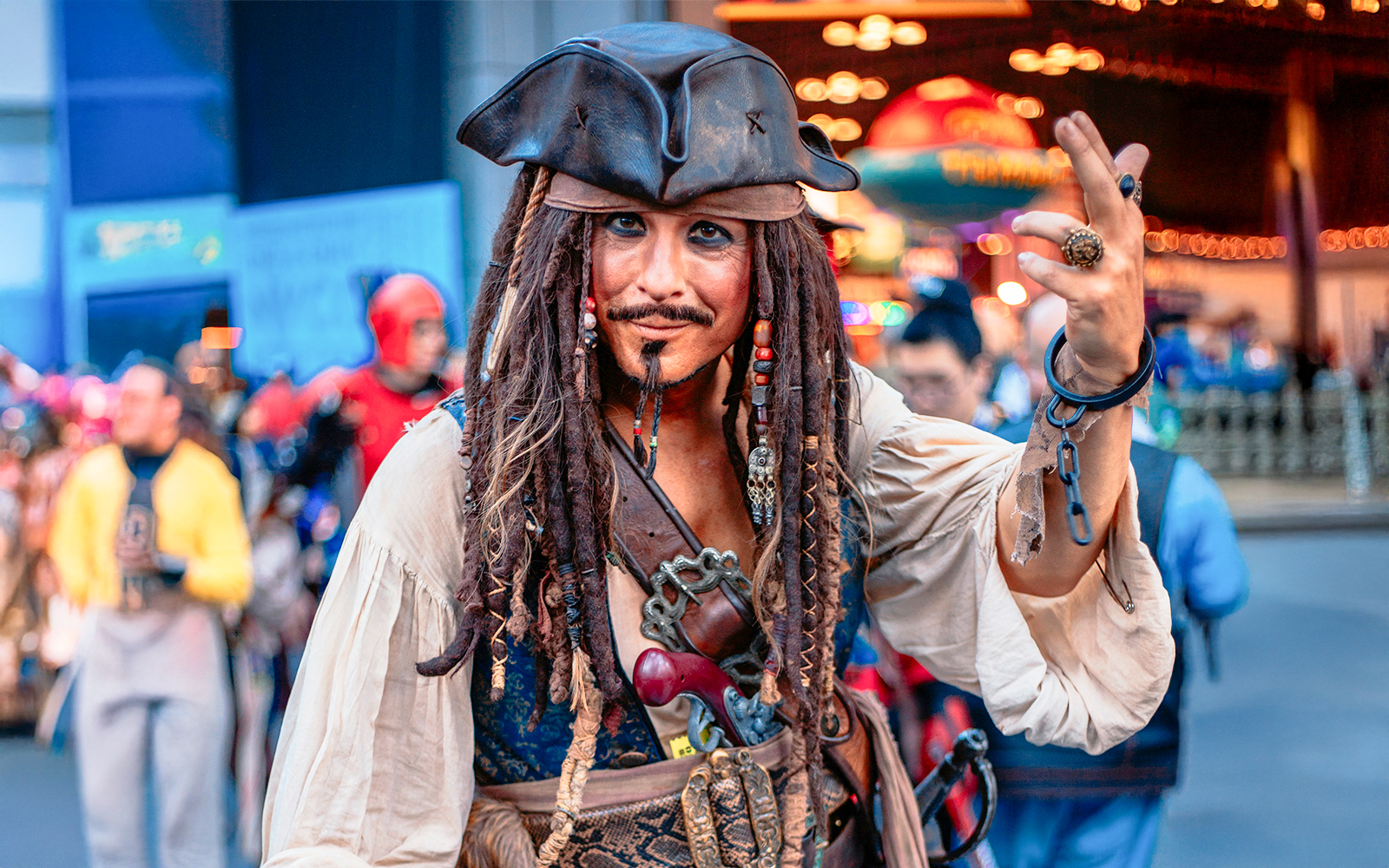Jack Sparrow cosplayer at Walt Disney World, posing with a crowd in the background.