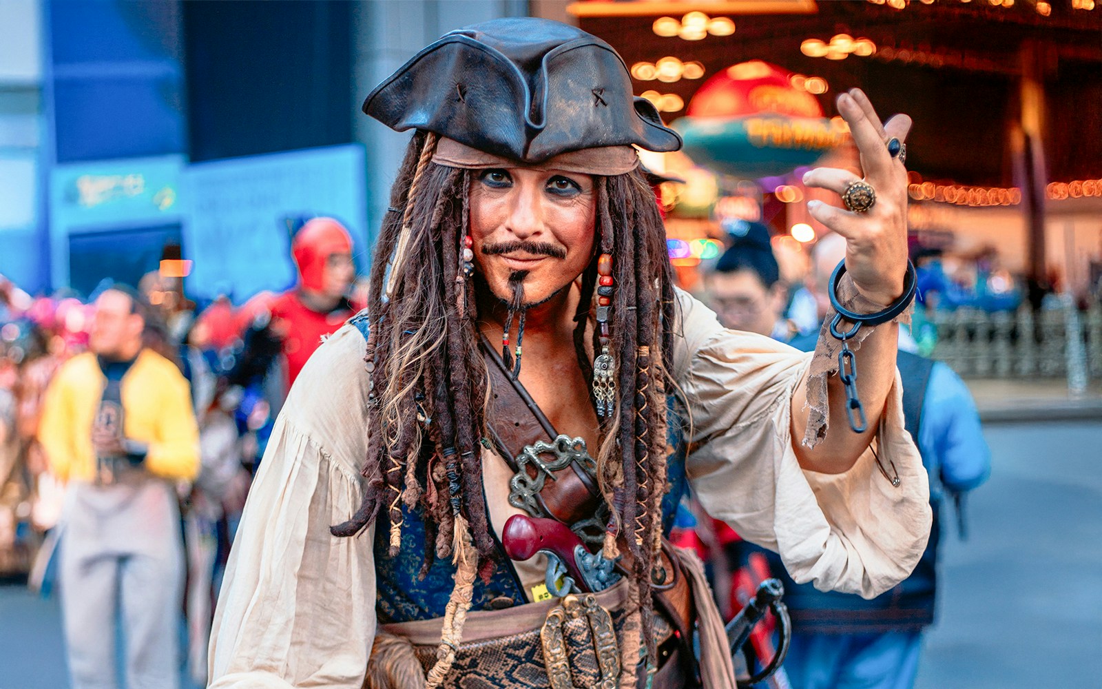 Jack Sparrow cosplayer at Walt Disney World, Orlando, posing with a crowd in the background.