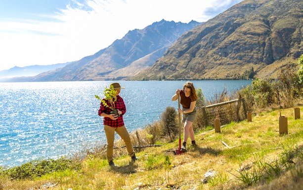 People planting trees by Lake Wakatipu during the TSS Earnslaw Cruise, Queenstown.