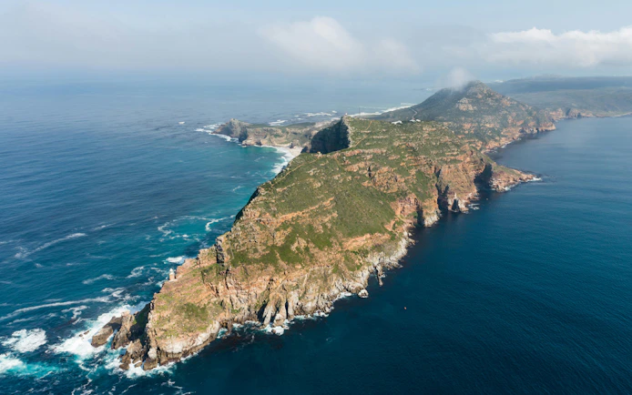 Aerial view of Cape Point and Cape of Good Hope, South Africa, with rugged cliffs and ocean.
