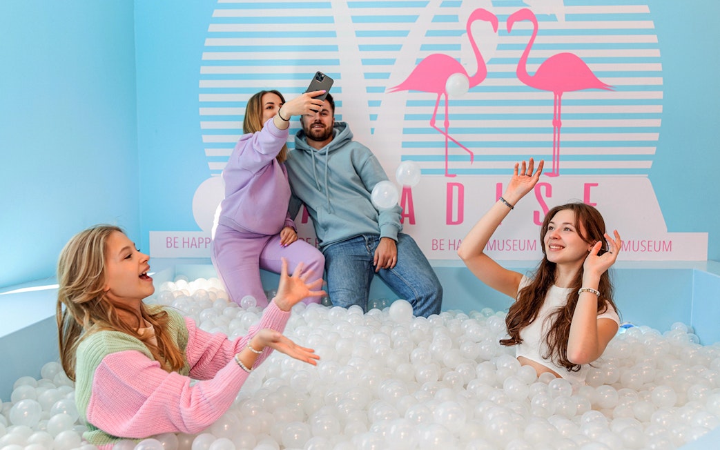 Visitors enjoying a ball pit inside Be Happy Museum in Krakow.
