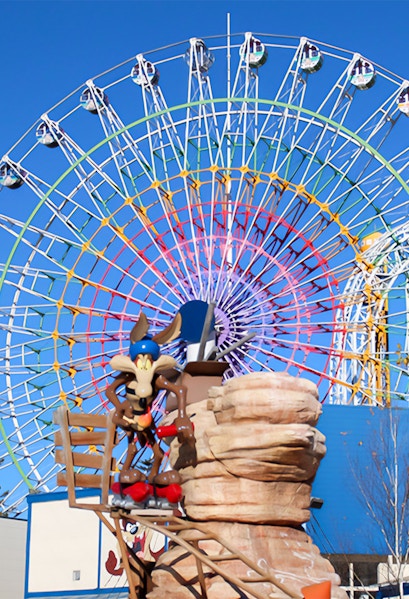 Ferris wheel and cartoon character statue at FujiQ Highland, Japan.