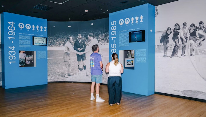Visitors exploring historical exhibits at the velodrome stadium tour.