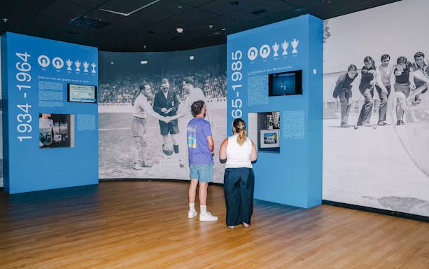 Visitors exploring historical exhibits at the velodrome stadium tour.