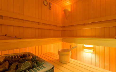 Sauna interior with wooden benches and bucket, part of Cleopatra Bath experience in Hurghada.
