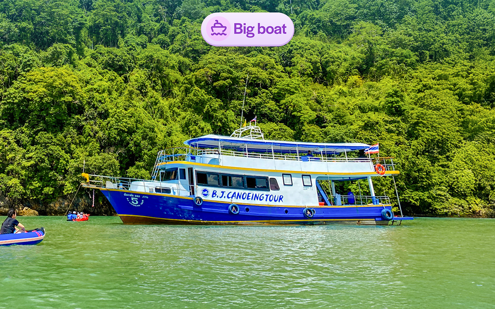 Tourists canoeing near a tour boat at Phang Nga Bay, Thailand.