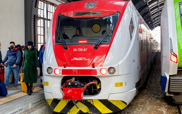 Malpensa Express train at Milan Cadorna Station platform with passengers nearby.