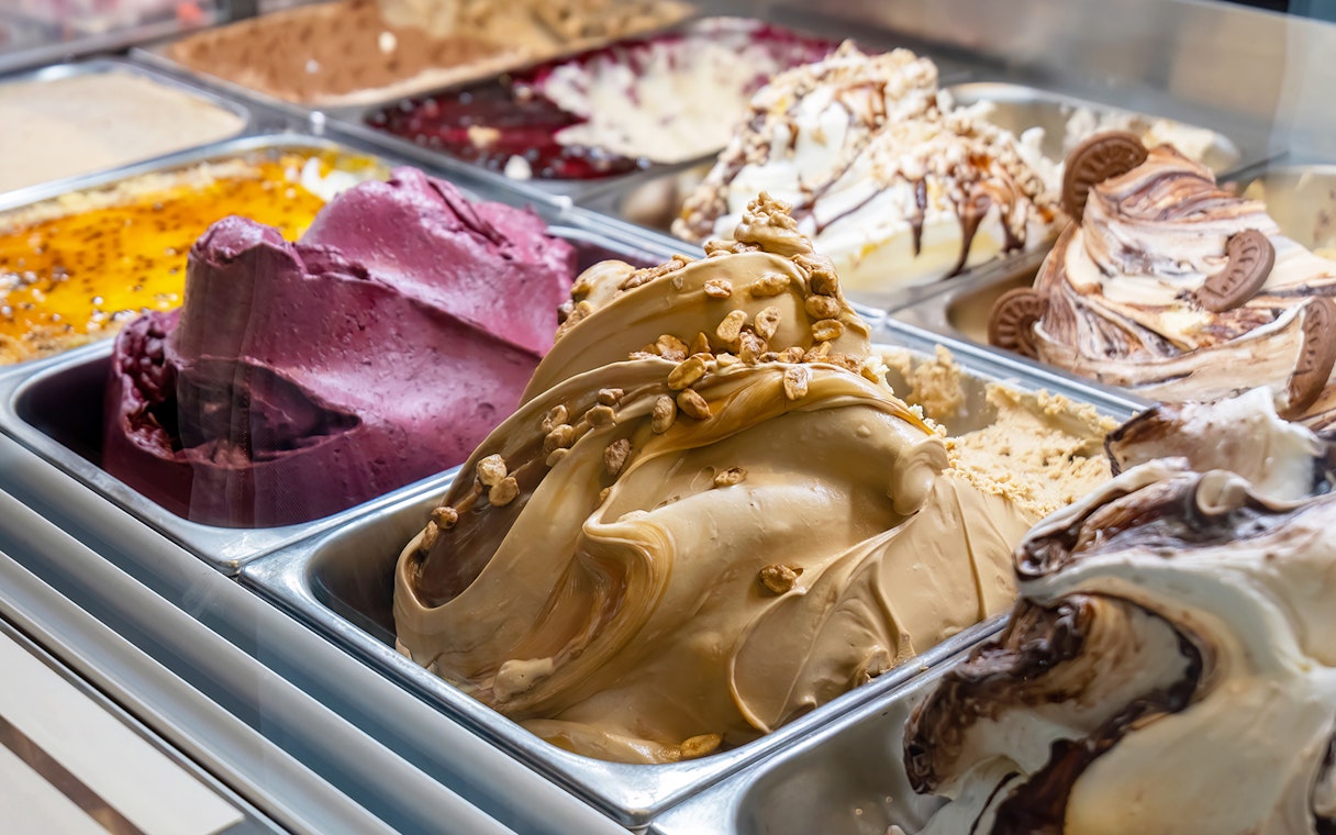 Variety of gelato flavors in a display case, including chocolate and fruit options.