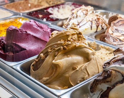 Variety of gelato flavors in a display case, including chocolate and fruit options.
