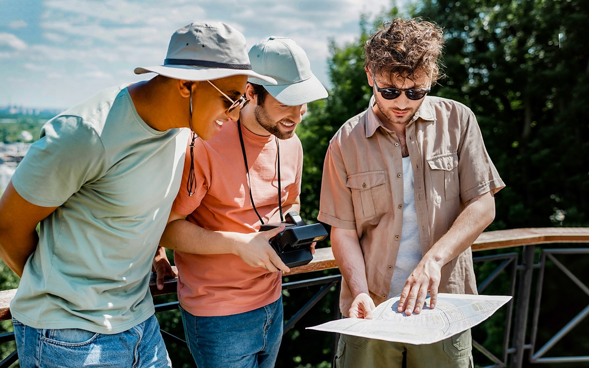 Tourists examining a map during Mostar and Kravice Falls day tour.