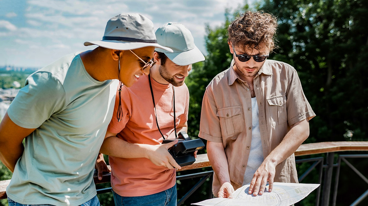 Tourists examining a map during Mostar and Kravice Falls day tour.