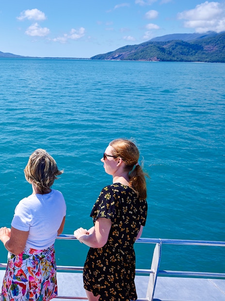 Tourists on a boat enjoying views of Fitzroy and Green Islands, Australia.
