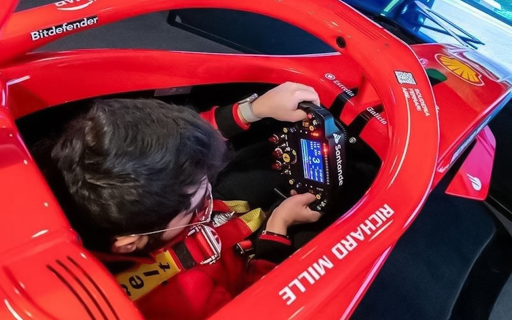 Person using a racing simulator at Enzo Ferrari House Museum.