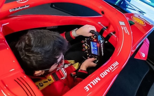 Person using a racing simulator at Enzo Ferrari House Museum.