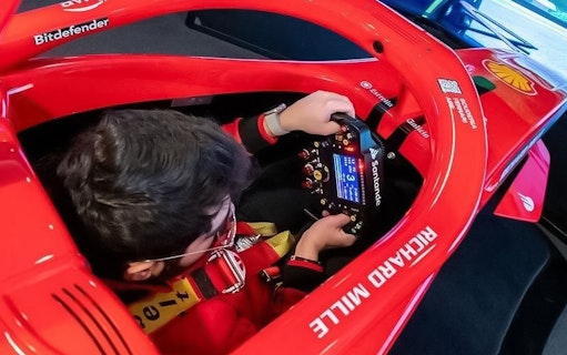 Person using a racing simulator at Enzo Ferrari House Museum.