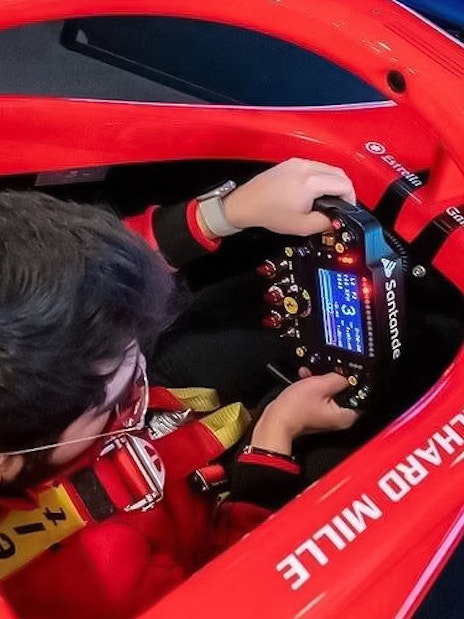 Person using a racing simulator at Enzo Ferrari House Museum.