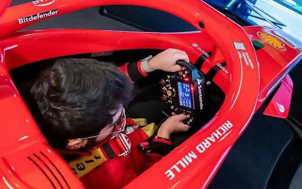 Person using a racing simulator at Enzo Ferrari House Museum.