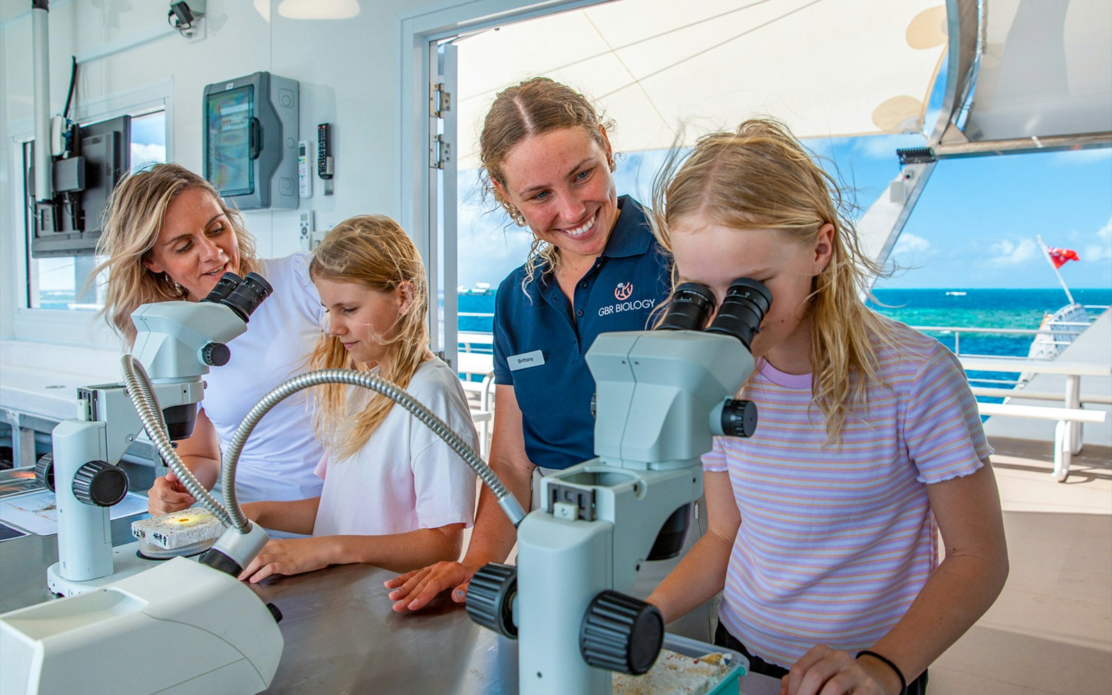Marine biologists and children using microscopes on a Great Barrier Reef cruise from Cairns.