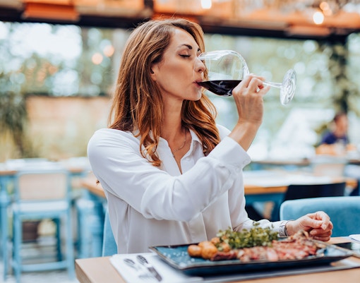 Woman dining at a modern Parisian restaurant, savoring French cuisine.