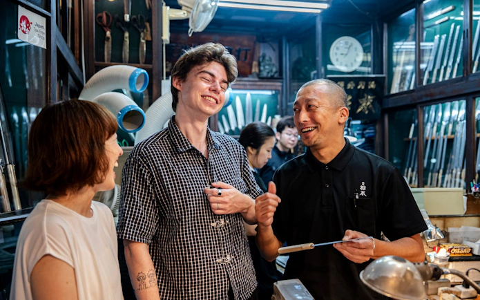 Visitors enjoying a knife shop tour in Tsukiji Market, Tokyo.