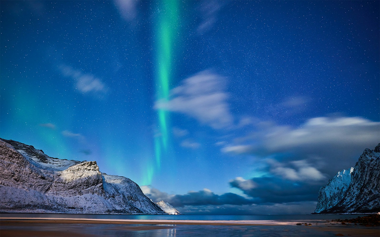Northern lights over snowy mountains in Ersfjorden, Norway.