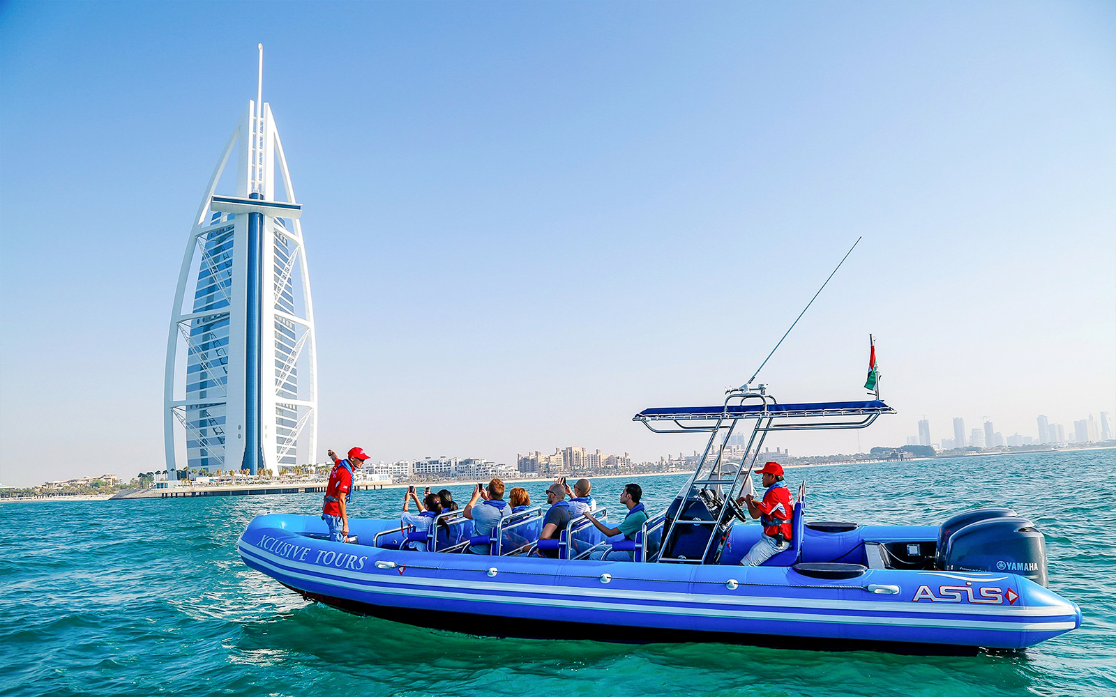 Boat tour near Burj Al Arab, Dubai, with tourists enjoying the view.