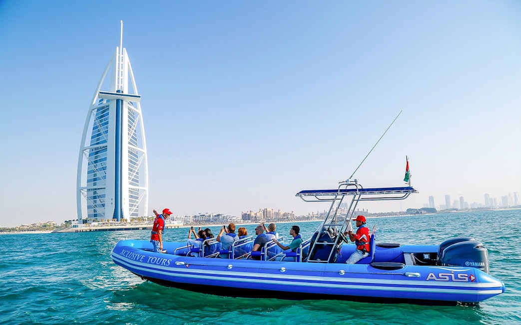 Boat tour near Burj Al Arab, Dubai, with tourists enjoying the view.