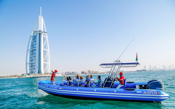 Boat tour near Burj Al Arab, Dubai, with tourists enjoying the view.
