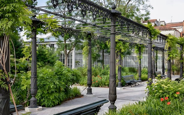 Pergola with greenery and benches in Royal Gardens near Illy Cafe.