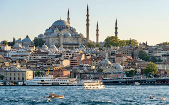 Süleymaniye Mosque overlooking the Bosphorus with boats in Istanbul.
