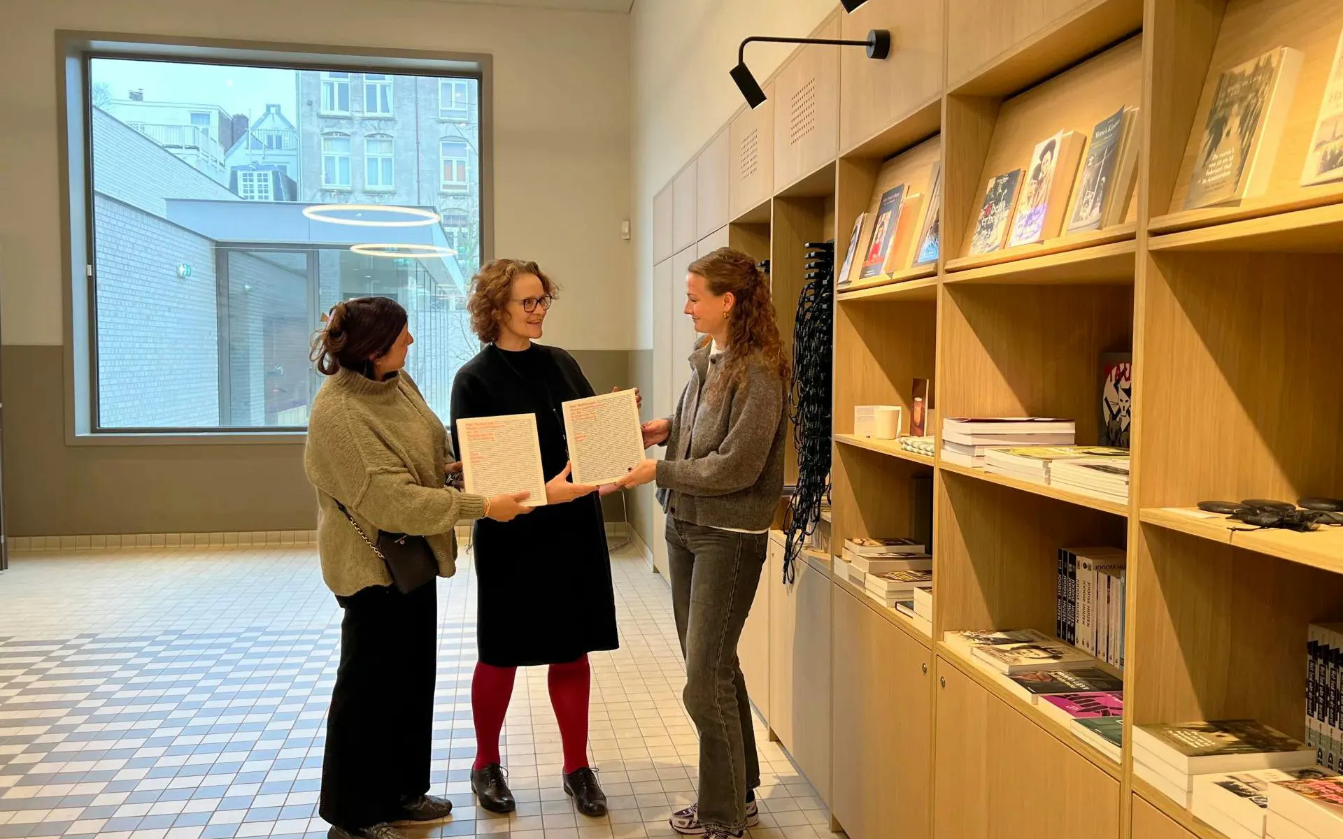 Three people holding documents in the National Holocaust Museum gift shop.