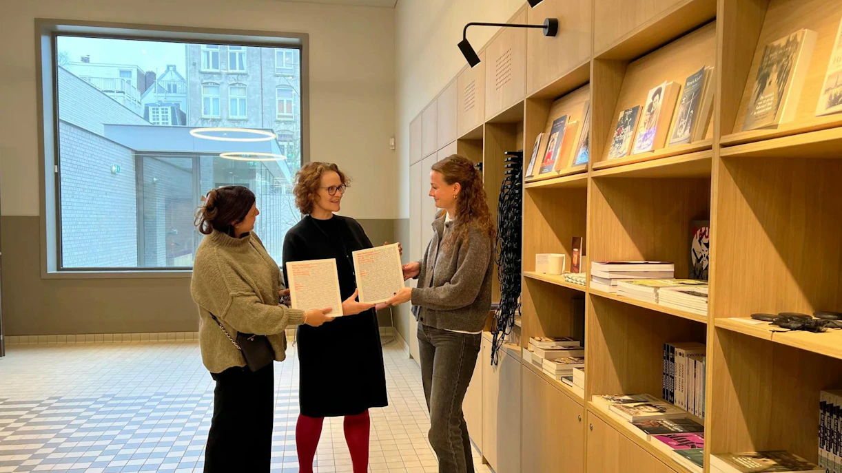 Three people holding documents in the National Holocaust Museum gift shop.