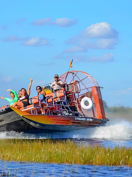 Airboat tour in Everglades Safari Park with passengers enjoying the ride, Miami.
