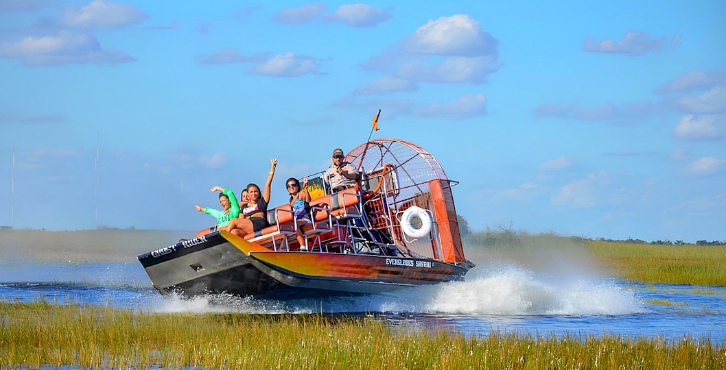 Airboat tour in Everglades Safari Park with passengers enjoying the ride, Miami.