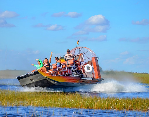 Airboat tour in Everglades Safari Park with passengers enjoying the ride, Miami.