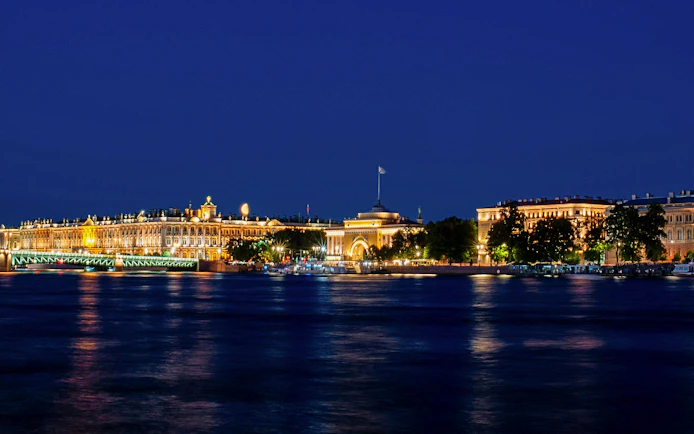 Night view of illuminated buildings along the river in Lisbon.