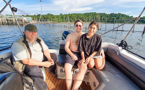 Tourists enjoying a boat ride near a kelong in Singapore.