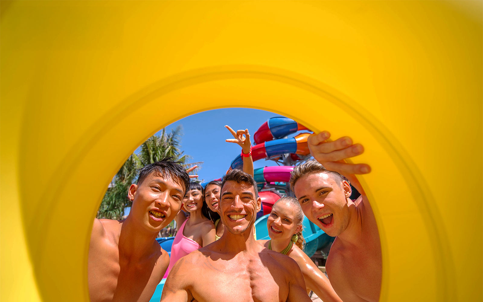 Group enjoying a water park with colorful slides in the background.