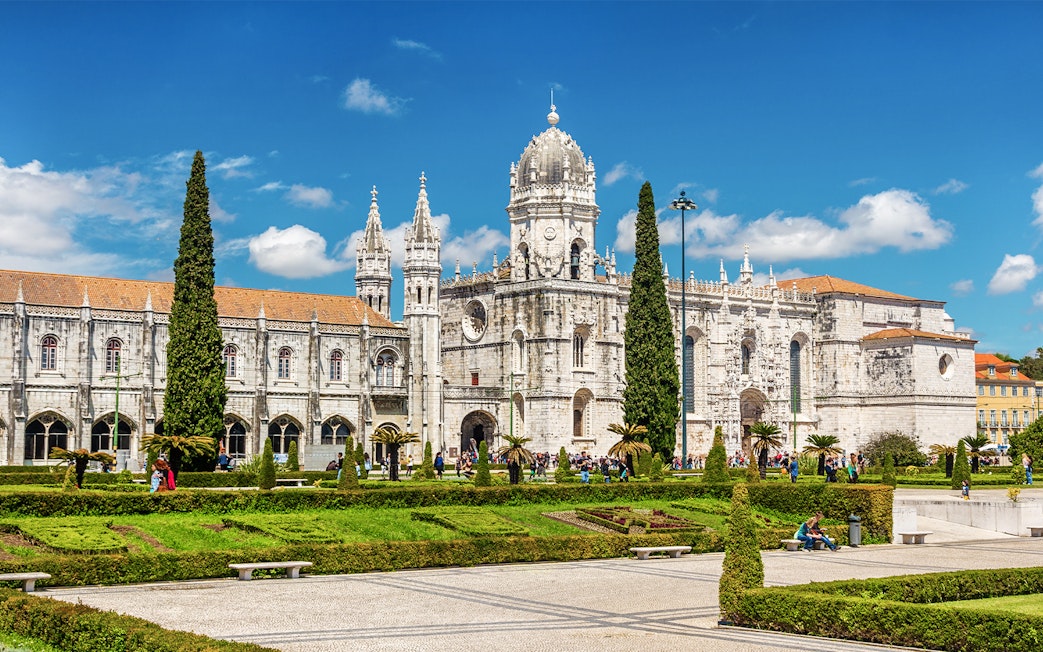 Jeronimos Monastery in Lisbon with ornate architecture and manicured gardens.